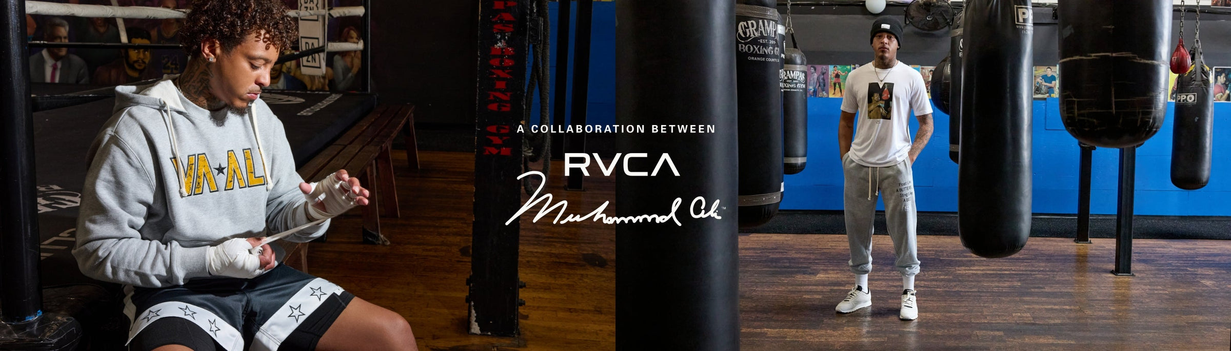 Two men in a boxing gym wear RVCA x Muhammad Ali apparel; one sits wrapping his hands, the other stands among punching bags. Collaboration branding is displayed in the center.
