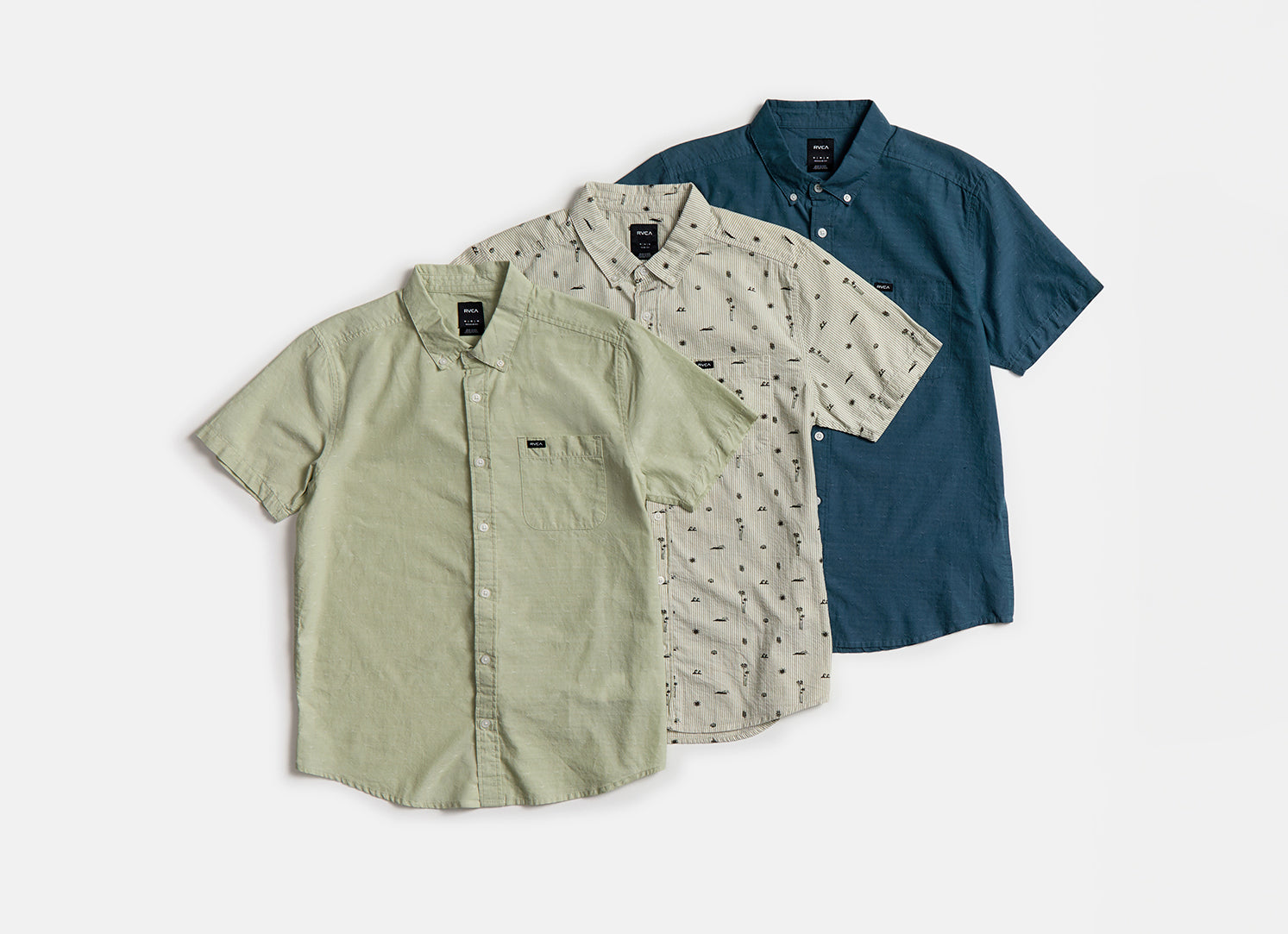 Three short-sleeve shirts in green, beige, and blue on a white background