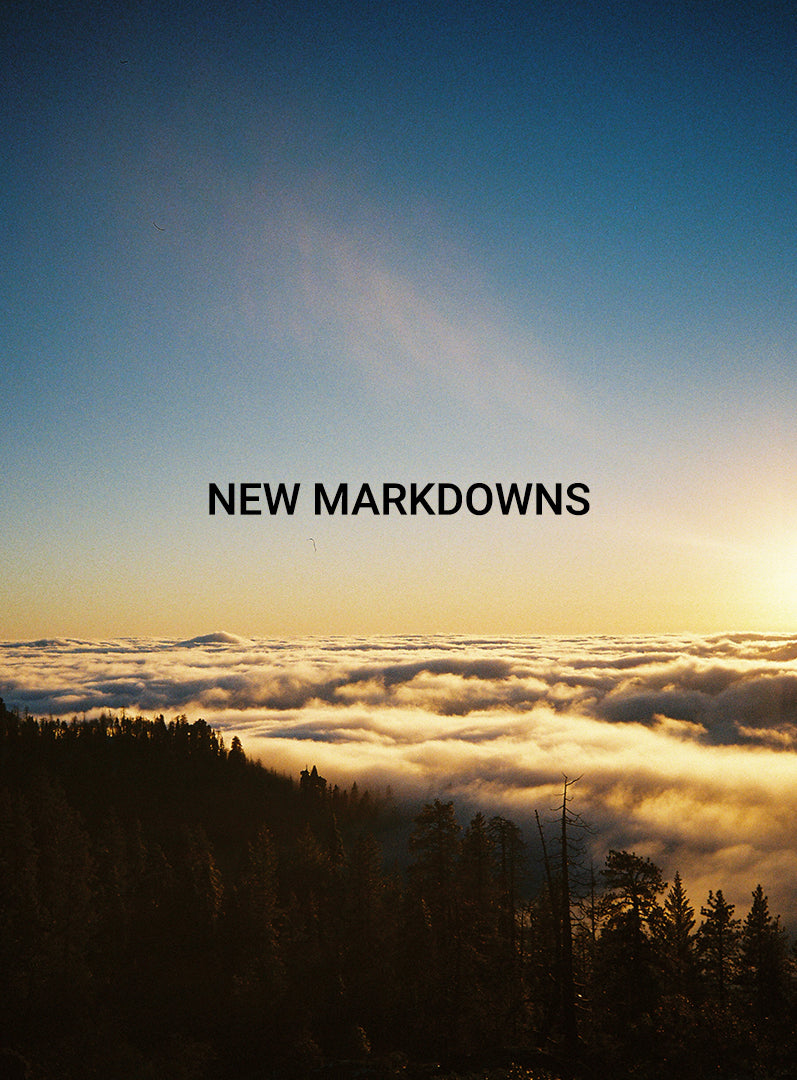 Scenic view of a forest with clouds and a rainbow, overlaid with NEW MARKDOWNS text