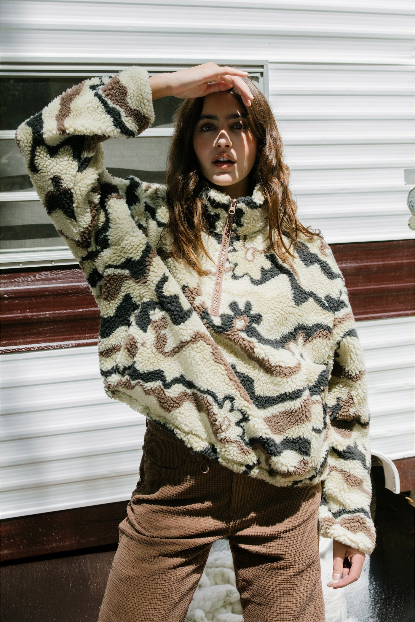 Person wearing a patterned fleece pullover in an indoor setting