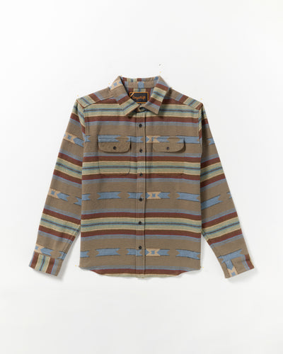 The Dayshift Blanket Flannel Long Sleeve Shirt features a southwestern-inspired pattern in brown, blue, and tan with two chest pockets, button flaps, and a pointed collar. Laid flat on a white background.