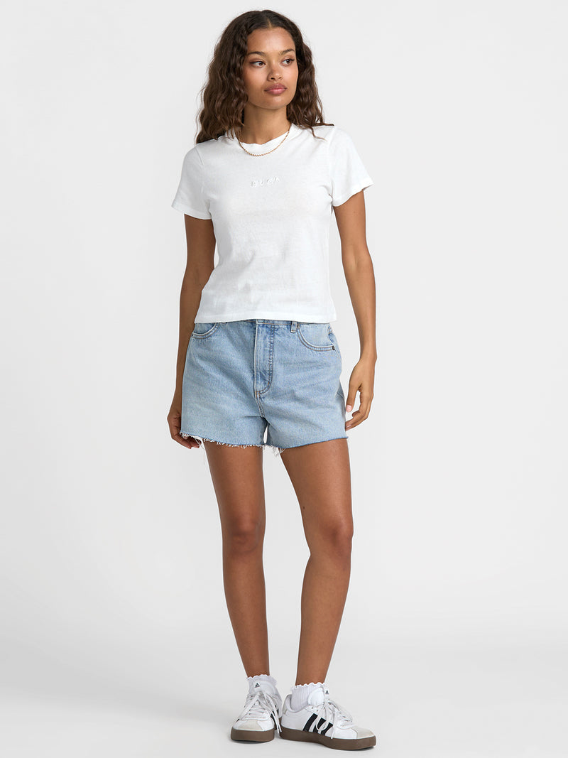 Woman wearing a white t-shirt and light blue denim shorts on a white background