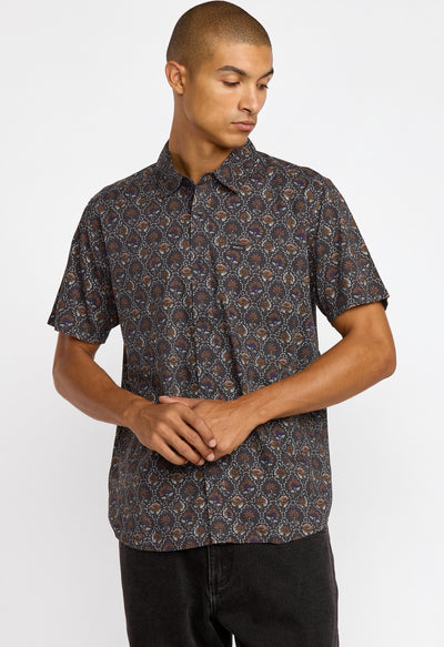 Man wearing a patterned shirt against a white background