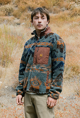 Man wearing a patterned pullover in a natural setting